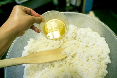 sushi rice vinegar pouring into short-grain sushi rice